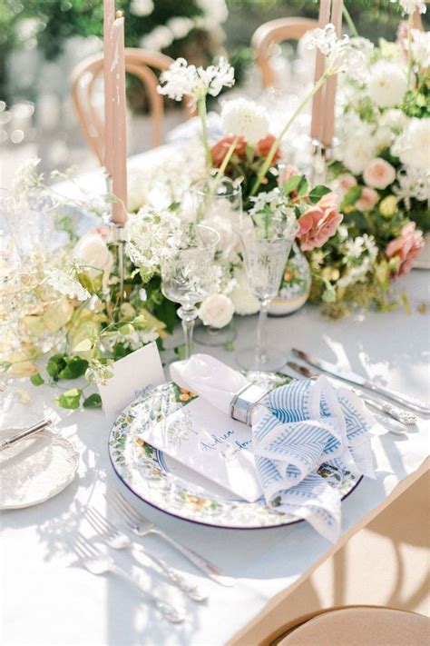 The Table Is Set With White And Pink Flowers