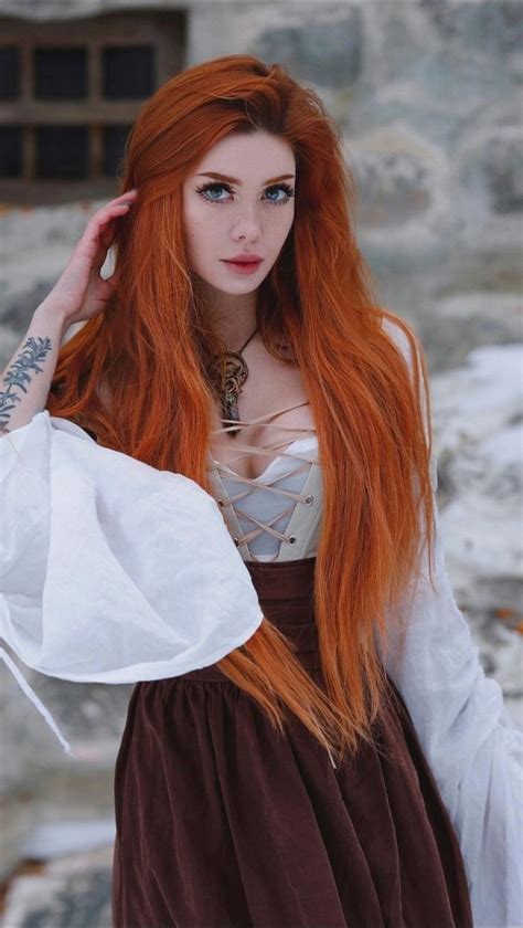 A Woman With Long Red Hair Wearing A Dress