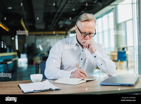 Mature Businessman Working While Sitting In The Office A Middle Aged