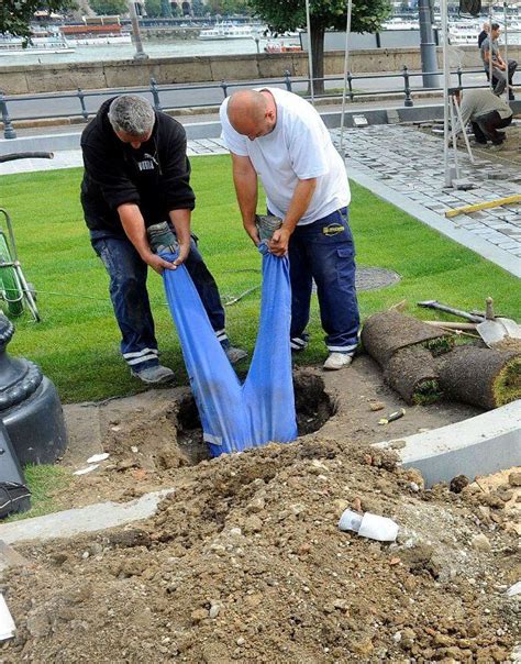 Two Men Are Working On The Ground With Blue Tarps