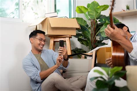 Gay Couple Enjoying Moments While Unpacking Boxes In Their New Home Stock Photo Image Of