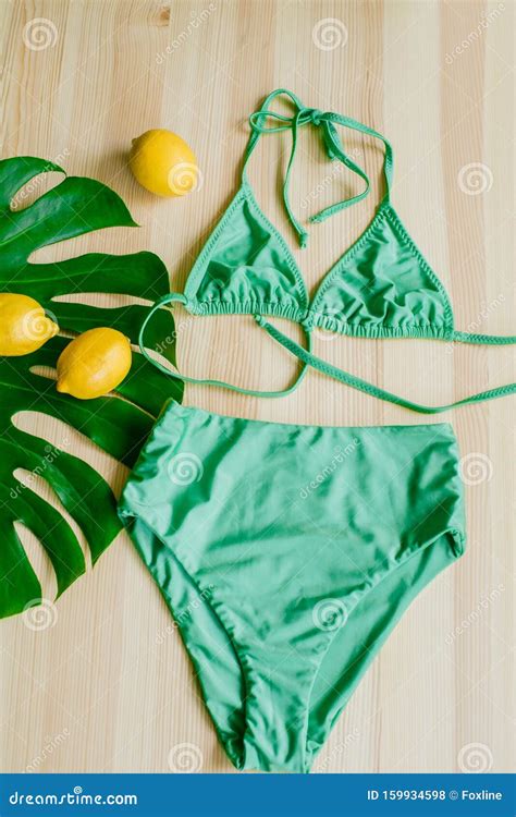 Bright Trendy Bikini On A Wooden Background With Yellow Lemons