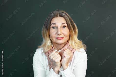 Emotional Mature Woman Raising Eyebrows Having Fascinated Look Staring At Camera In