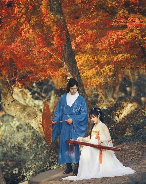 Two Women Dressed In Traditional Japanese Clothing Standing Next To