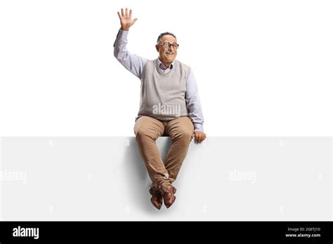 Casual Mature Man Sitting On A Blank Panel And Waving At Camera