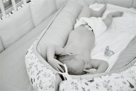 A Baby Boy Sleeps In A Cocoon On A Cot A Newborn Baby In A Diaper Is Lying Naked On The Bed