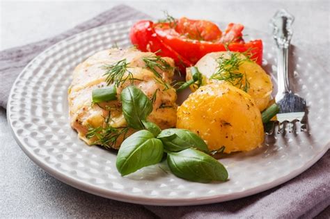 Premium Photo | Baked potatoes with chicken and vegetables on a plate