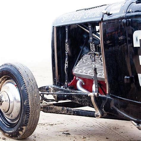 An Old Race Car Is Parked On The Ground With Its Front Tire Missing