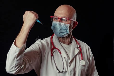 Portrait Of A Bald Doctor With Syringe Full With Blue Color Vaccine