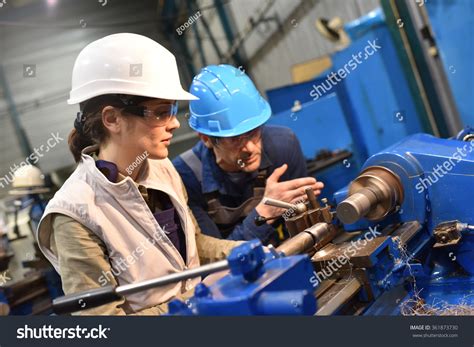 Metal Worker Teaching Trainee On Machine Stock Photo