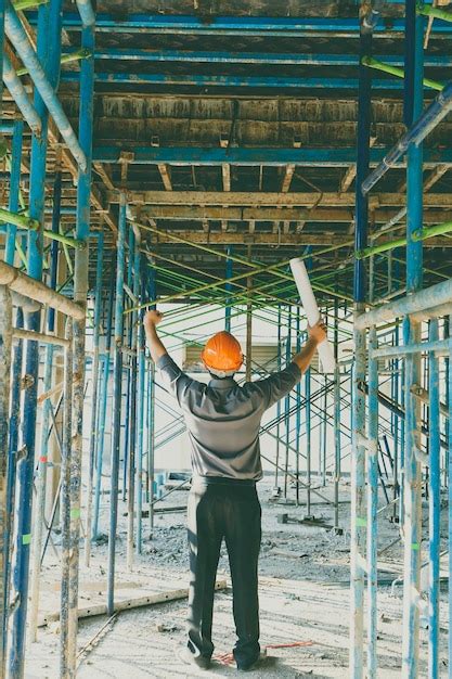 Vista trasera de un hombre trabajando en una estructura metálica Foto