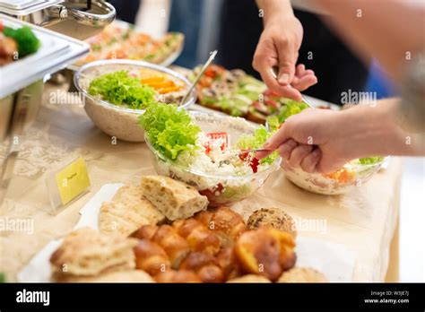 Hands Picking Up Food From Buffet Catering Table At Event Stock Photo