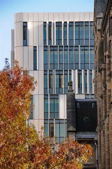 A Tall Building With Many Windows Next To Trees