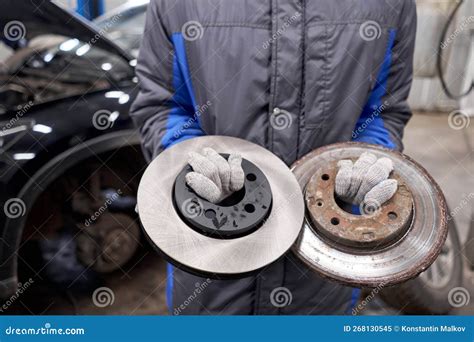 The Mechanic Holds Old Rusty Brake Disc And New Disc Change The Old To