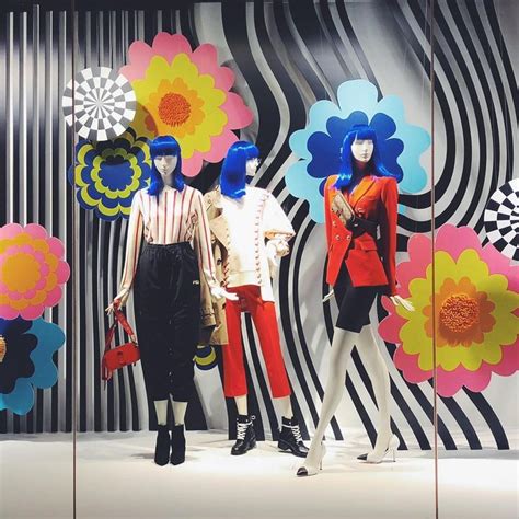 Three Mannequins Dressed In Brightly Colored Clothing With Flowers On