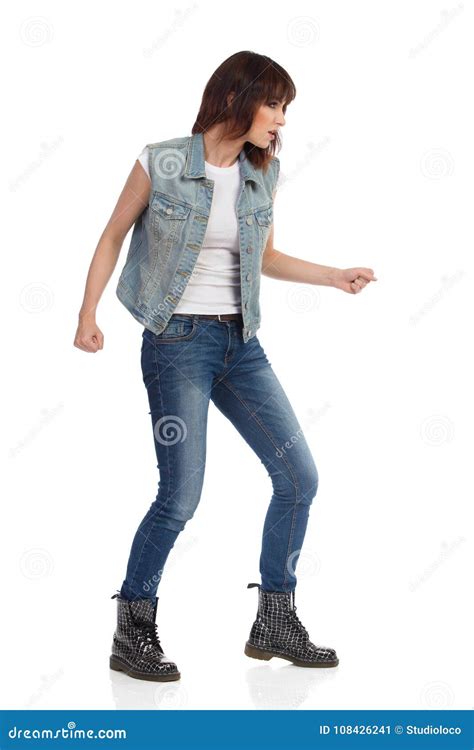 Young Woman In Jeans Vest And Black Boots Is Sneaking Stock Image