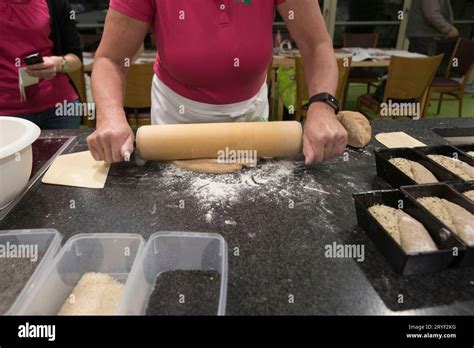 Woman Using A Rolling Pin Forming Bread Dough Stock Photo Alamy