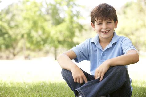 Retrato Do Menino Novo Que Senta Se No Parque Foto De Stock Imagem De