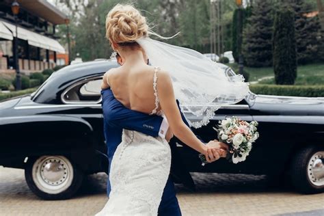 Casal de casamento de luxo dançando no carro velho em luz elegante