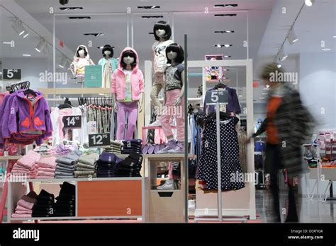 Shopper Choosing Dress In Child Clothes Shop Stock Photo Alamy