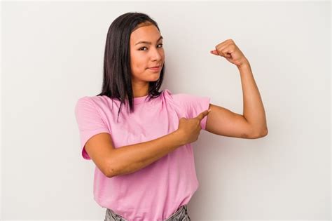 Jovem mulher latina isolada no fundo branco mostrando força gesto os braços símbolo do