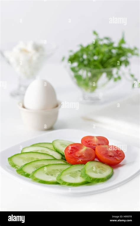 Sliced Tomato And Cucumber On A Plate White Background High Key