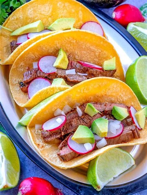 3 Carne Asada Street Tacos On A Plate With Radishes Chopped Onions