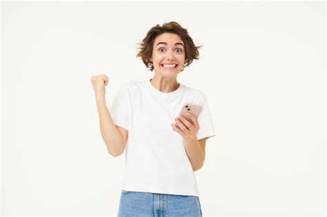 Free Photo Portrait Of Excited Brunette Woman Holding Smartphone And Celebrating Big Win