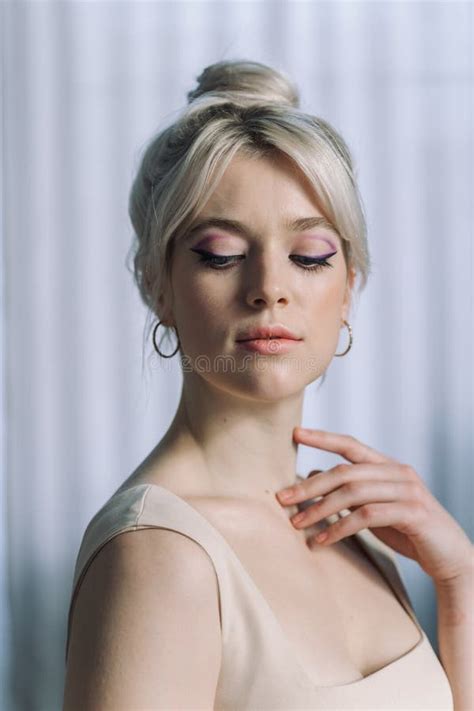 Close Up Studio Portrait Of A Pretty Blonde Woman Looking Down Stock