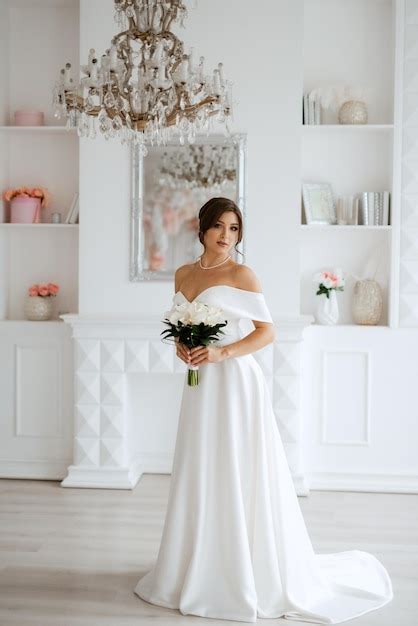 Premium Photo Brunette Bride In A Tight Wedding Dress In A Bright Studio