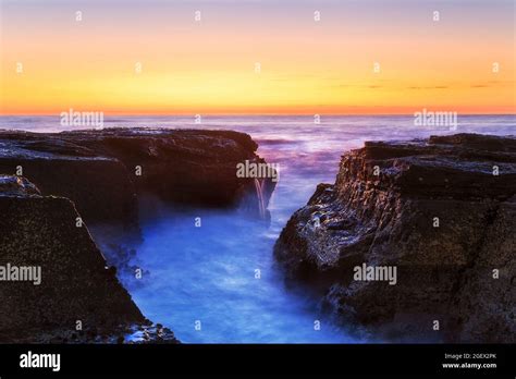 Colourful Dawn Sky Over Pacific Ocean Horizon With Wet Rocks Washed By