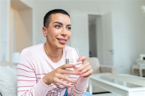 Mujer Africana Joven En Ropa Informal Bebiendo Agua De Vidrio Foto