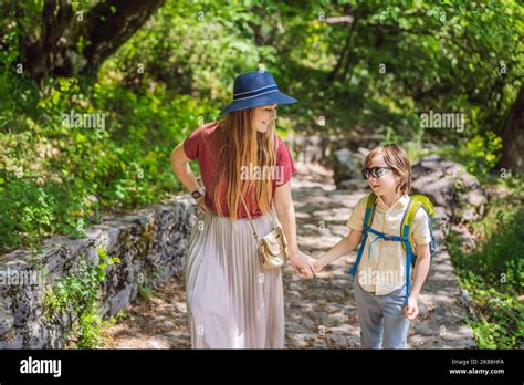 Mother and son tourists climb the mountain to the Ostrog temple. Monastery of Ostrog, Serbian ...