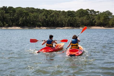 Mãe e criança brincando no rio ou lago caiaque para umas férias