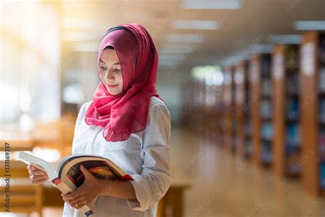 Beautiful Muslim Girl Reading Book With Hijab On Blur Library Background Stock 写真 Adobe Stock