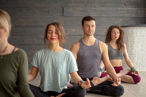 Group Of Young Sporty People Practicing Yoga Lesson Sitting In