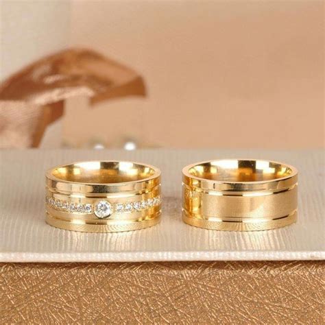 Two Gold Wedding Rings Sitting On Top Of A Table