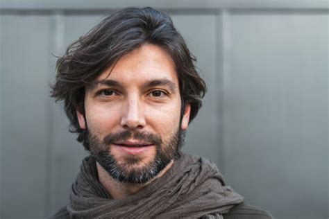 Portrait Of Man Wearing Scarf In Front Of Gray Wall Stock Photo