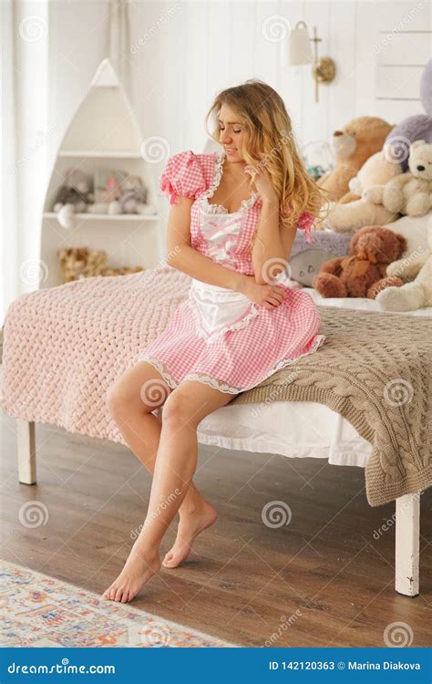 Pretty Adult Girl In Pink Cute Dress In Her White Bedroom With Many