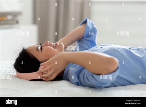 Happy Asian Woman Laying On Bed Listening To Music Stock Photo Alamy