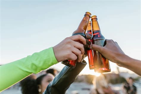 2 Person Holding Glass Bottles · Free Stock Photo