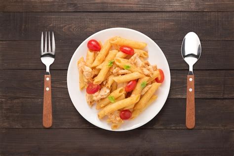 Penne Pasta En Salsa De Tomate Con Pollo Sobre Un Fondo De Madera Foto Premium