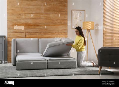 Young Woman Unfolding Sofa Into A Bed In Room Modern Interior Stock