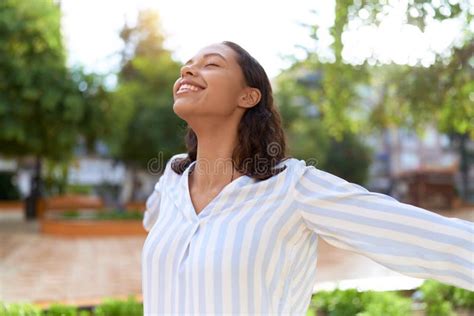 Young African American Woman Breathing With Closed Eyes At Park Stock