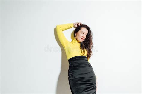 Beautiful Brunette Woman Posing Against A White Wall Stock Photo