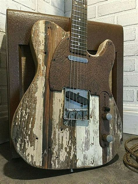 An Old Guitar Sitting On Top Of A Wooden Stand In Front Of A Brick Wall