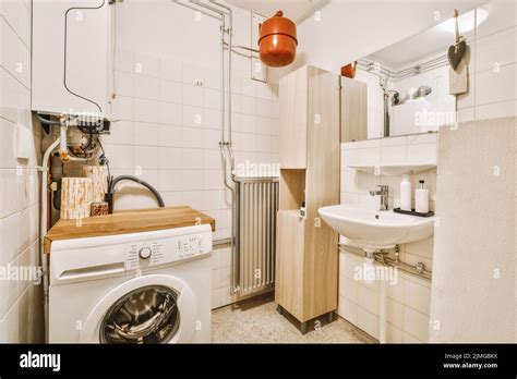 Interior Of Narrow Restroom With Sink And Wall Hung Toilet With White