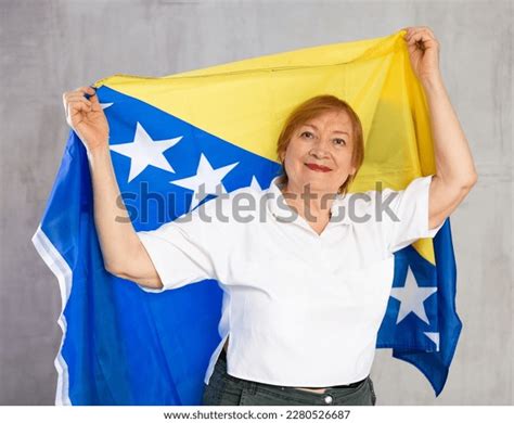 Happy Mature Lady Standing Proudly Holding Stock Photo