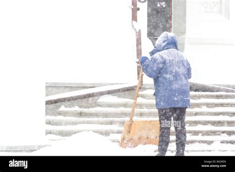One women shovelling snow in the snowstrom. Cleaning stairs Stock Photo ...