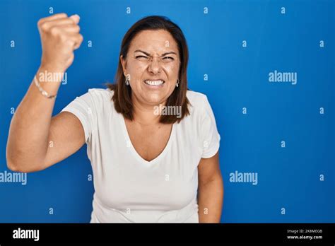 Hispanic Mature Woman Standing Over Blue Background Angry And Mad